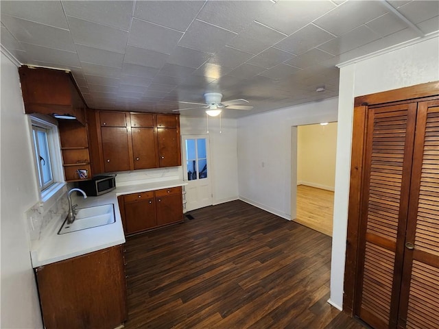 kitchen with dark hardwood / wood-style flooring, ceiling fan, and sink