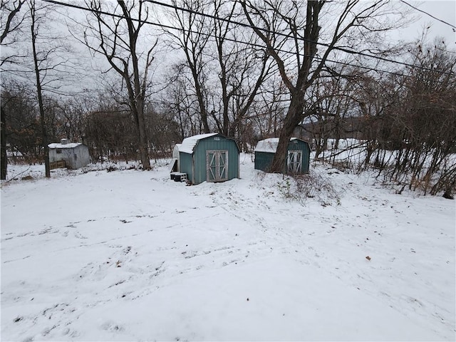 yard covered in snow with a storage shed