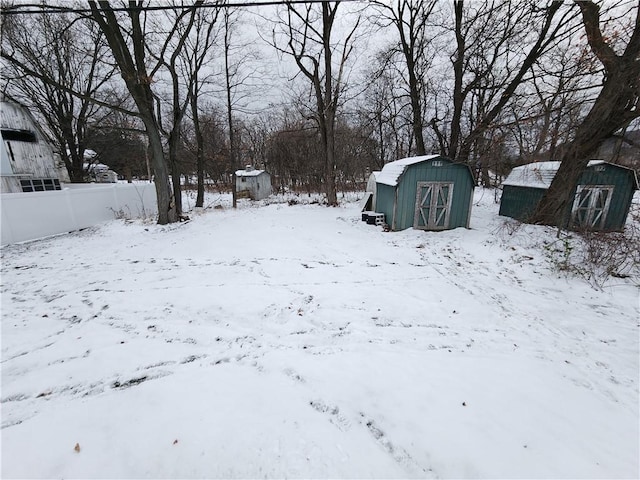 yard layered in snow featuring a storage unit