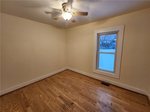 spare room with light wood-type flooring and ceiling fan