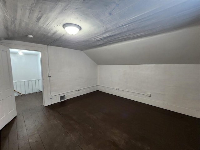 bonus room with dark hardwood / wood-style floors and vaulted ceiling