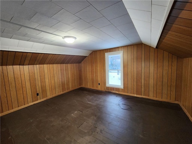 additional living space featuring wood walls, dark wood-type flooring, and lofted ceiling