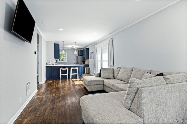 living room with dark hardwood / wood-style flooring and crown molding