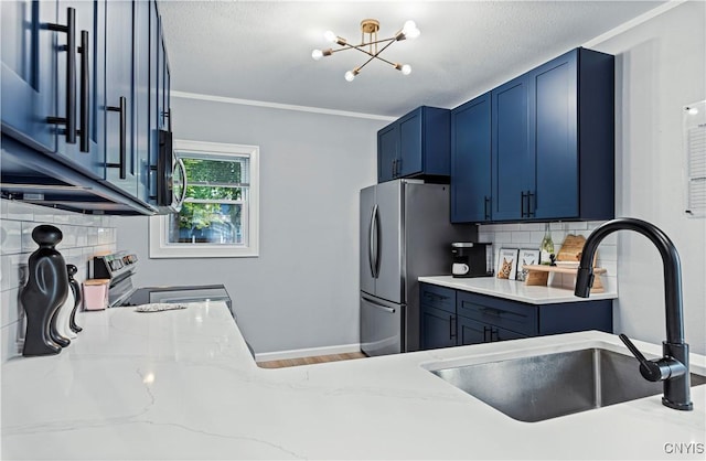 kitchen with decorative backsplash, appliances with stainless steel finishes, light stone countertops, ornamental molding, and sink