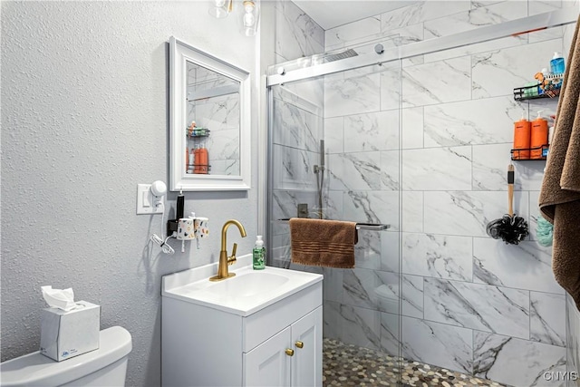 bathroom with vanity, an enclosed shower, and toilet