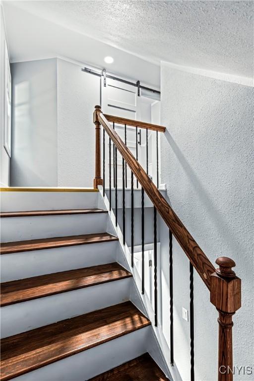 stairs with a textured ceiling