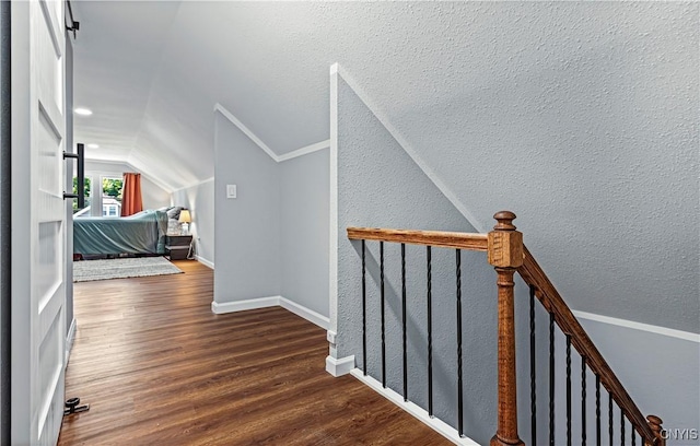 hall featuring hardwood / wood-style floors, crown molding, and lofted ceiling