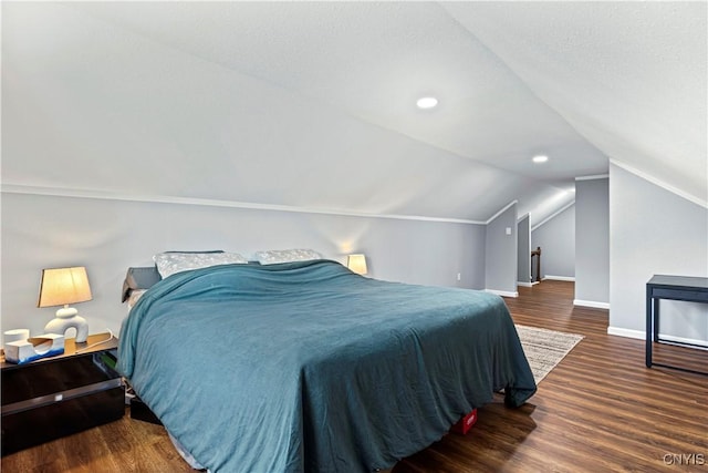 bedroom with vaulted ceiling, a textured ceiling, and dark hardwood / wood-style floors