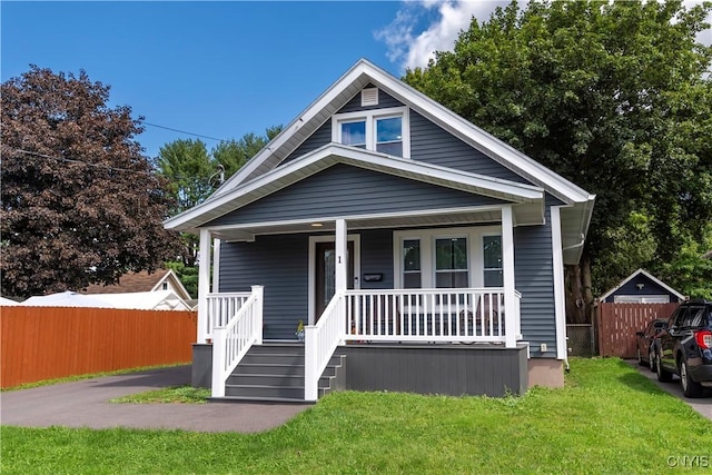 bungalow-style home with covered porch and a front yard