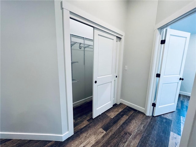 corridor with dark hardwood / wood-style flooring