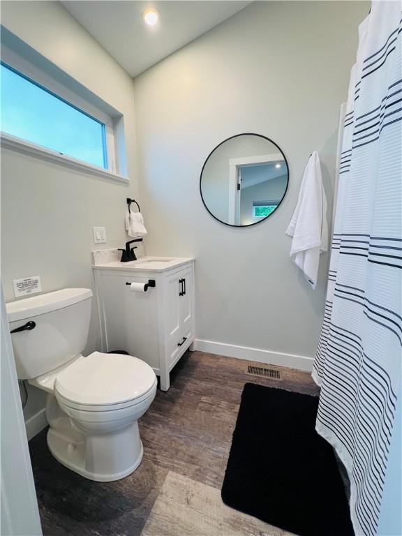 bathroom with toilet, vanity, and hardwood / wood-style flooring