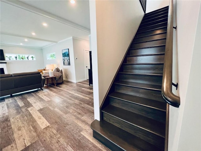 stairs featuring hardwood / wood-style flooring, beam ceiling, and crown molding