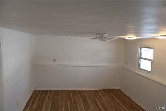 spare room featuring wood finished floors and baseboards
