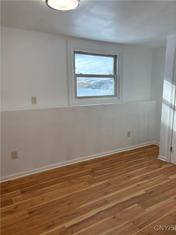 empty room featuring light wood finished floors and baseboards