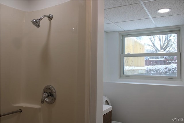 bathroom featuring a paneled ceiling and a shower