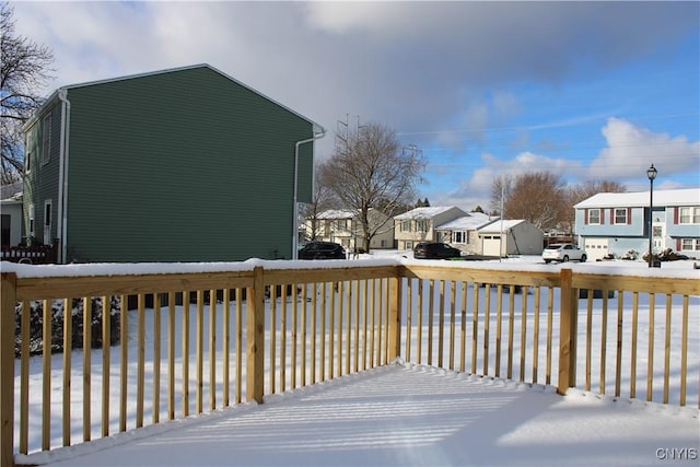 snow covered deck with a residential view