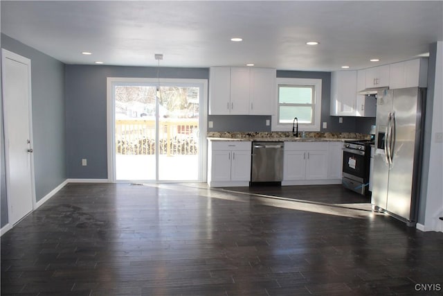 kitchen with dark wood-style flooring, white cabinetry, stainless steel appliances, and a sink