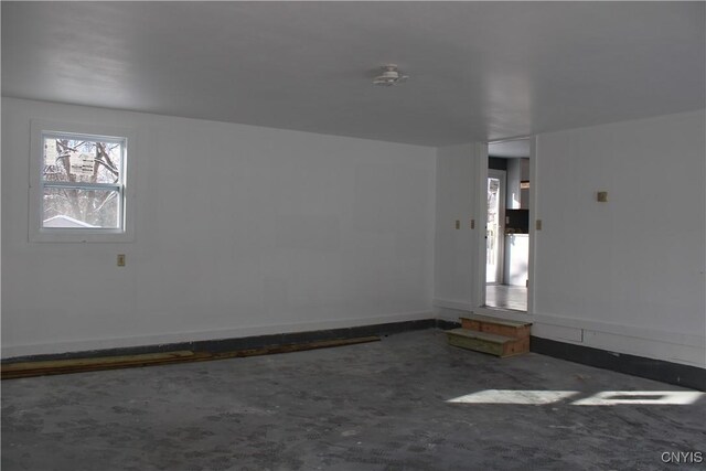empty room featuring baseboards and unfinished concrete flooring