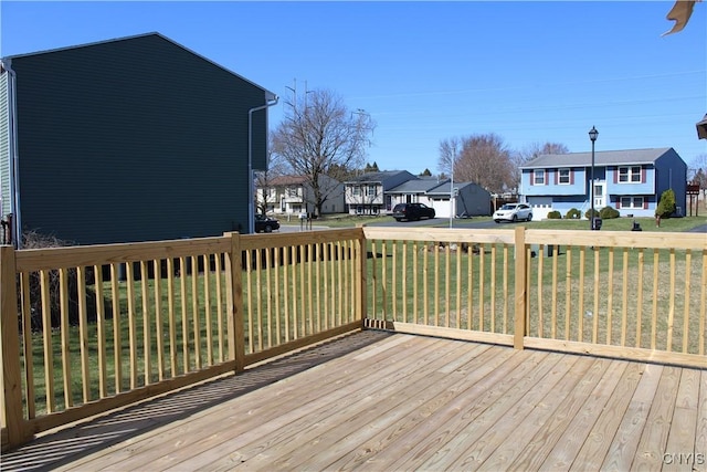 wooden deck with a residential view and a lawn