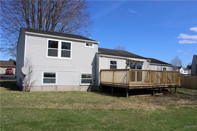 rear view of house featuring a wooden deck and a lawn