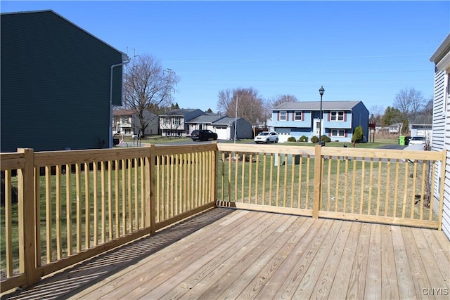 wooden deck with a residential view and a lawn