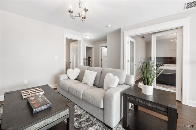 living room with dark hardwood / wood-style floors and a chandelier