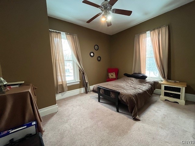 bedroom with light carpet, multiple windows, and ceiling fan