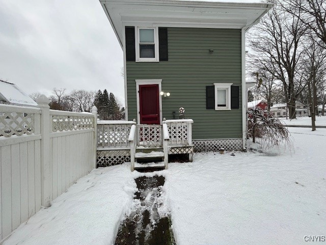 view of snow covered back of property