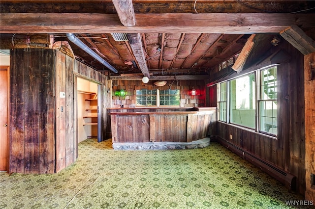 interior space featuring wooden walls and a baseboard heating unit