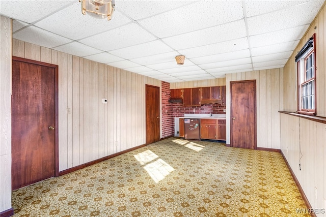 kitchen with a drop ceiling and wood walls