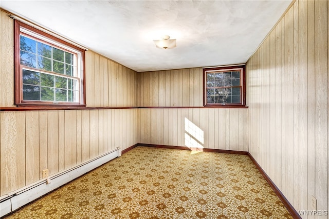 empty room with wooden walls and a baseboard radiator