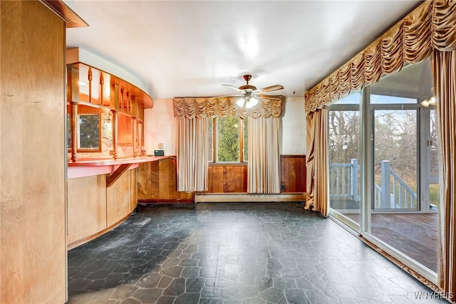 kitchen with a wealth of natural light, a baseboard heating unit, and ceiling fan