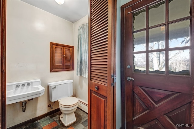 bathroom featuring a baseboard radiator, toilet, and sink