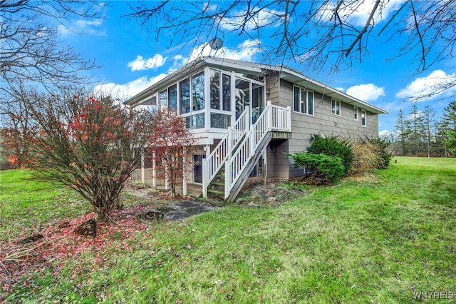 view of side of property featuring a sunroom and a yard