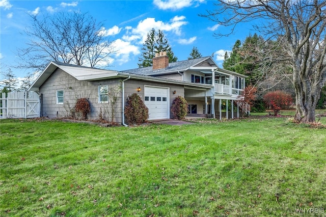 view of front facade with a sunroom, a garage, and a front lawn