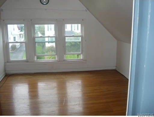 additional living space featuring hardwood / wood-style flooring and lofted ceiling