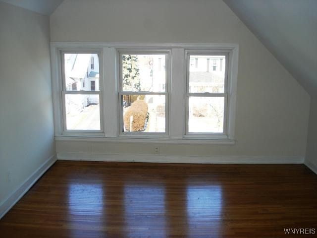 bonus room with dark hardwood / wood-style flooring and lofted ceiling