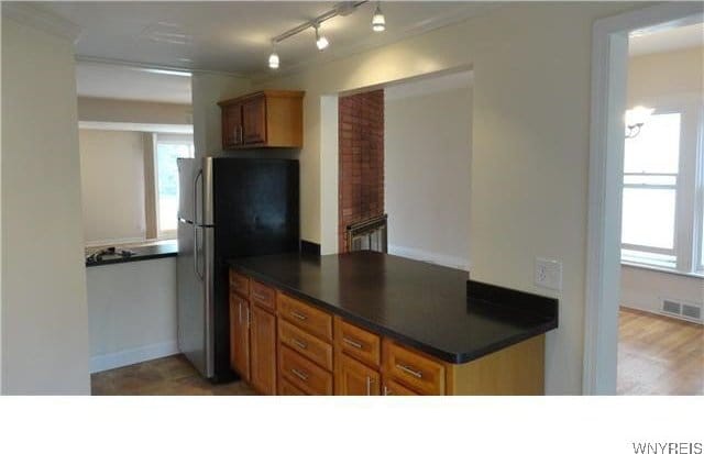 kitchen featuring stainless steel fridge and light hardwood / wood-style flooring