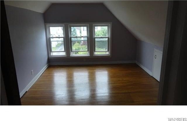 bonus room with hardwood / wood-style flooring and lofted ceiling