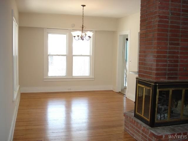 unfurnished dining area featuring hardwood / wood-style flooring and a notable chandelier