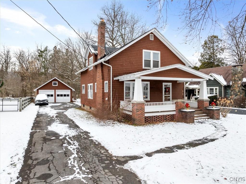 view of front of home featuring a porch, a garage, and an outdoor structure