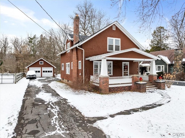 view of front of home featuring a porch, a garage, and an outdoor structure