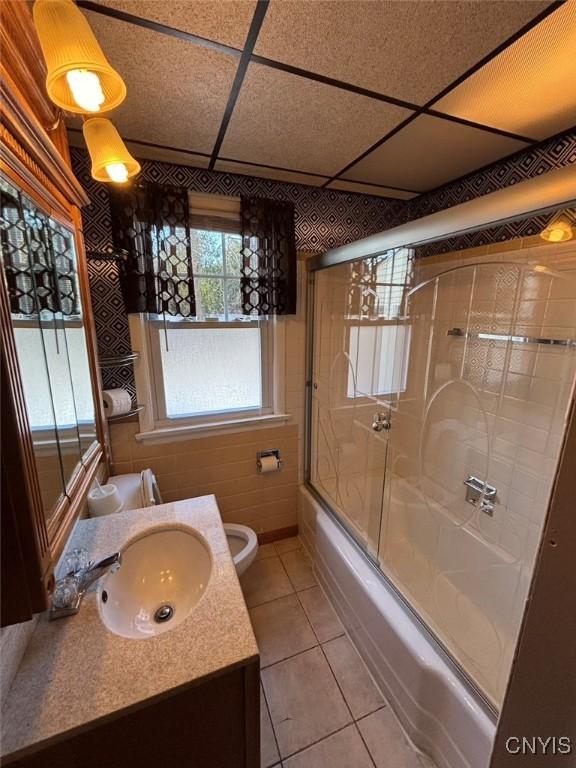 full bathroom featuring tile patterned flooring, vanity, toilet, and enclosed tub / shower combo