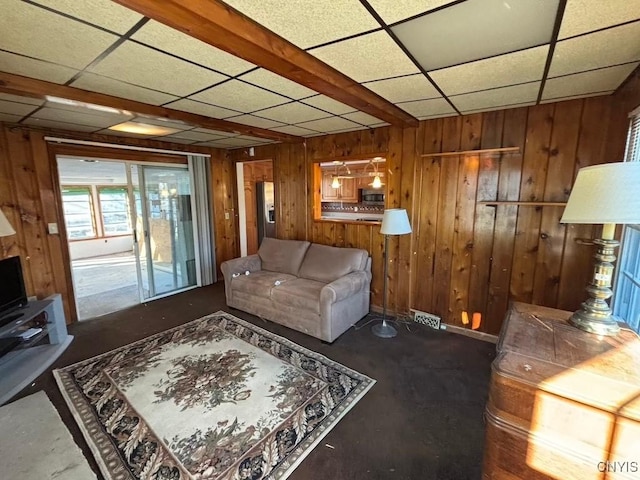 living room with a paneled ceiling and wooden walls