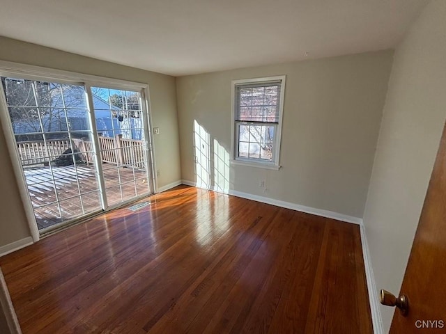 spare room featuring hardwood / wood-style floors and plenty of natural light