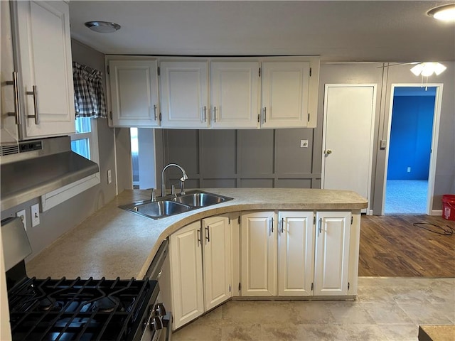 kitchen featuring sink, range hood, light hardwood / wood-style floors, white cabinetry, and gas stove