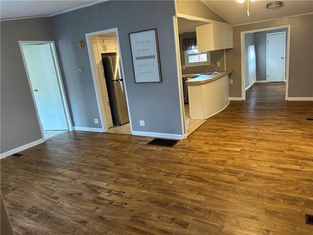 kitchen with stainless steel fridge, white cabinets, and dark hardwood / wood-style floors