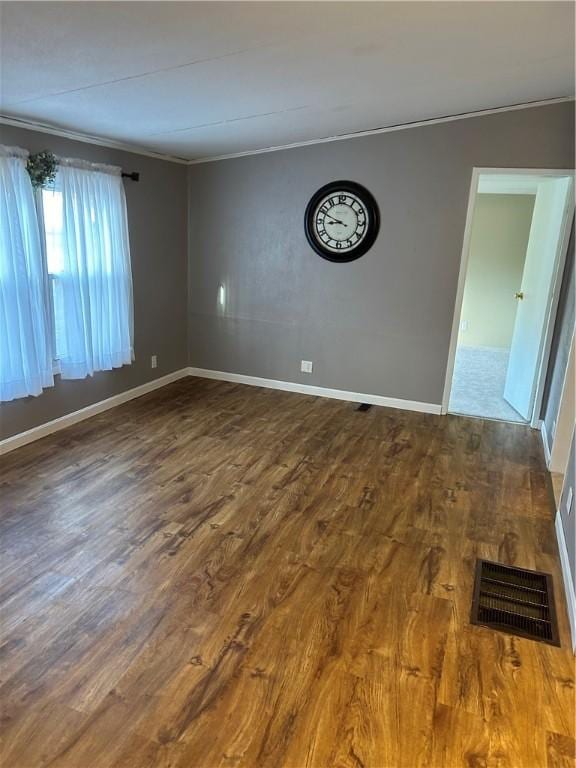 empty room with crown molding and wood-type flooring