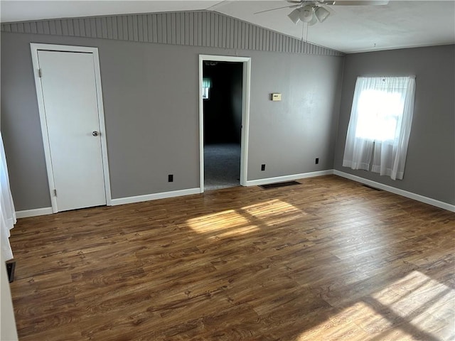 spare room featuring ceiling fan, dark hardwood / wood-style flooring, and lofted ceiling