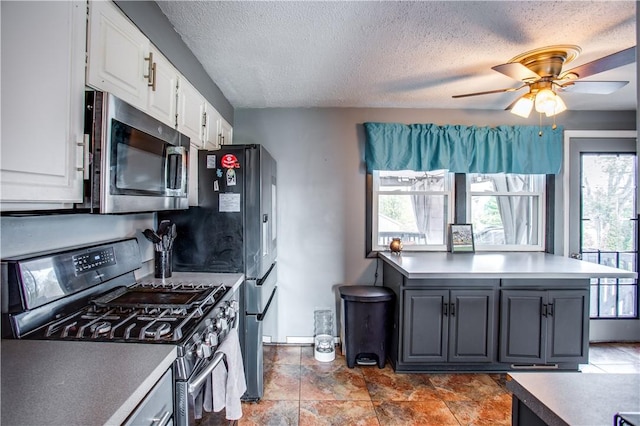 kitchen featuring a textured ceiling, ceiling fan, white cabinetry, and stainless steel appliances